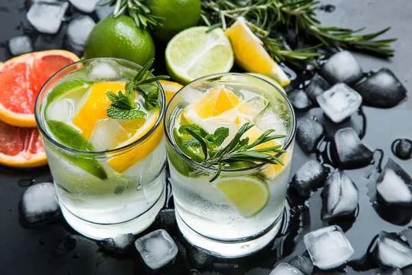 stock image Fresh summer cocktail with lime and ice on the black desk