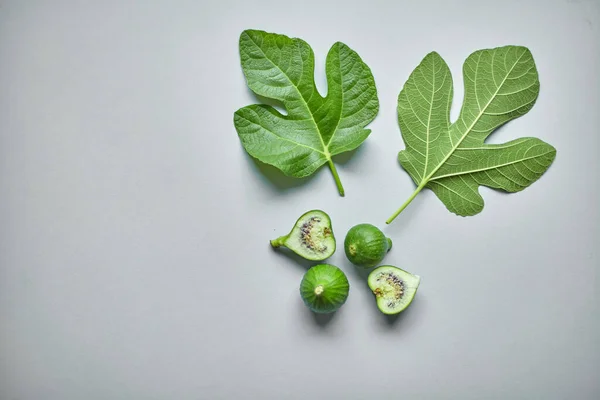 Green common fig with a leaf on grey background