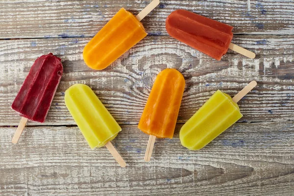 Tahta masada meyveli çubukta dondurma.