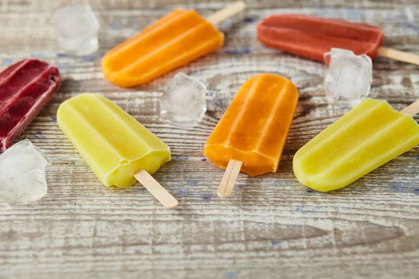 Ice cream on a stick  with fruit on the wooden table