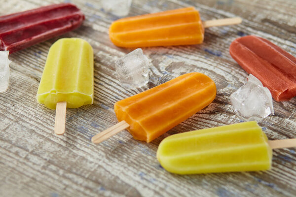 Ice cream on a stick  with fruit on the wooden table