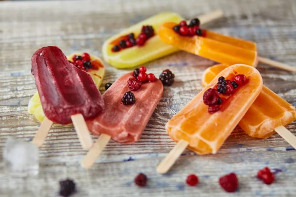 Ice cream on a stick  with fruit on the wooden table