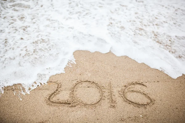 Nashledanou 2016 ručně psaného textu v písku beach — Stock fotografie