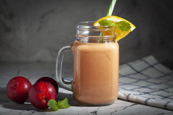 Fruit drink consisting of yogurt and plums whipped in a mixer. Healthy and tasty breakfast. A drink that is drunk through a straw.