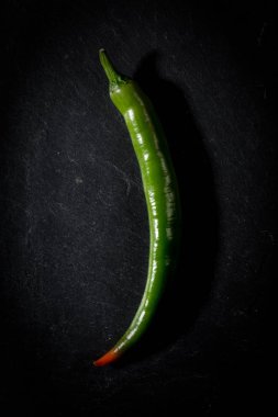 Siyah zemin üzerine yeşil sıcak biber.