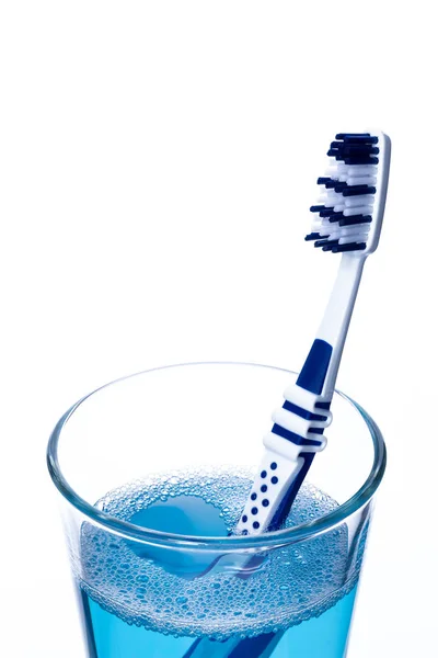 Toothbrush in glass with mouth rinse — Stock Photo, Image