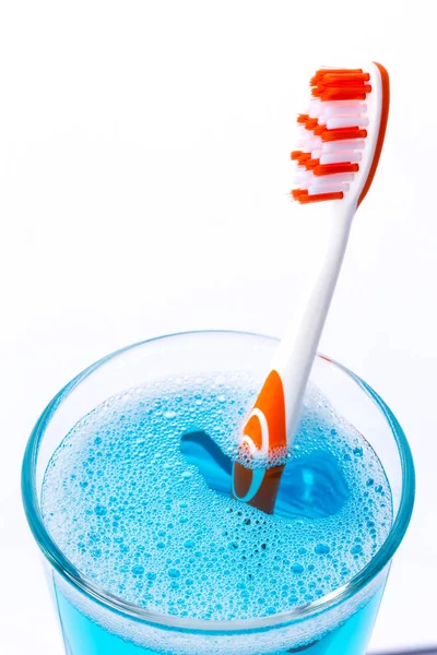 Toothbrush in glass with mouth rinse — Stock Photo, Image