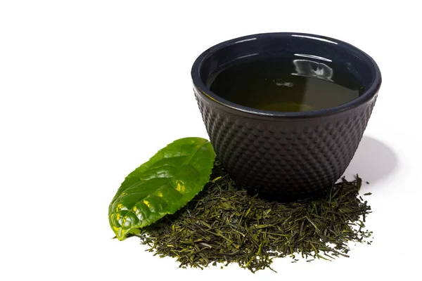 Tasse und Haufen grüner Shincha-Tee mit Blatt. — Stockfoto