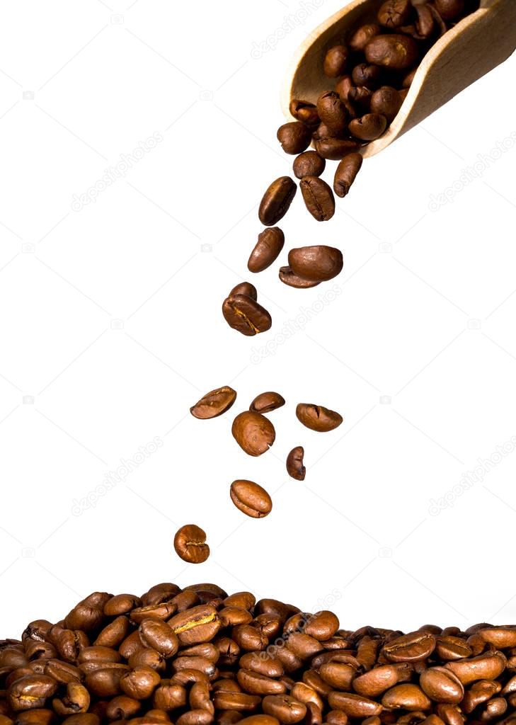 coffee beans falling on heap of coffee, isolated on white