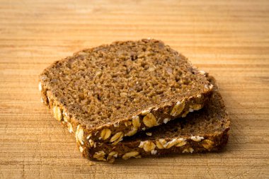 Ekmek bütün tahıl dilimleri ahşap tahta üzerinde