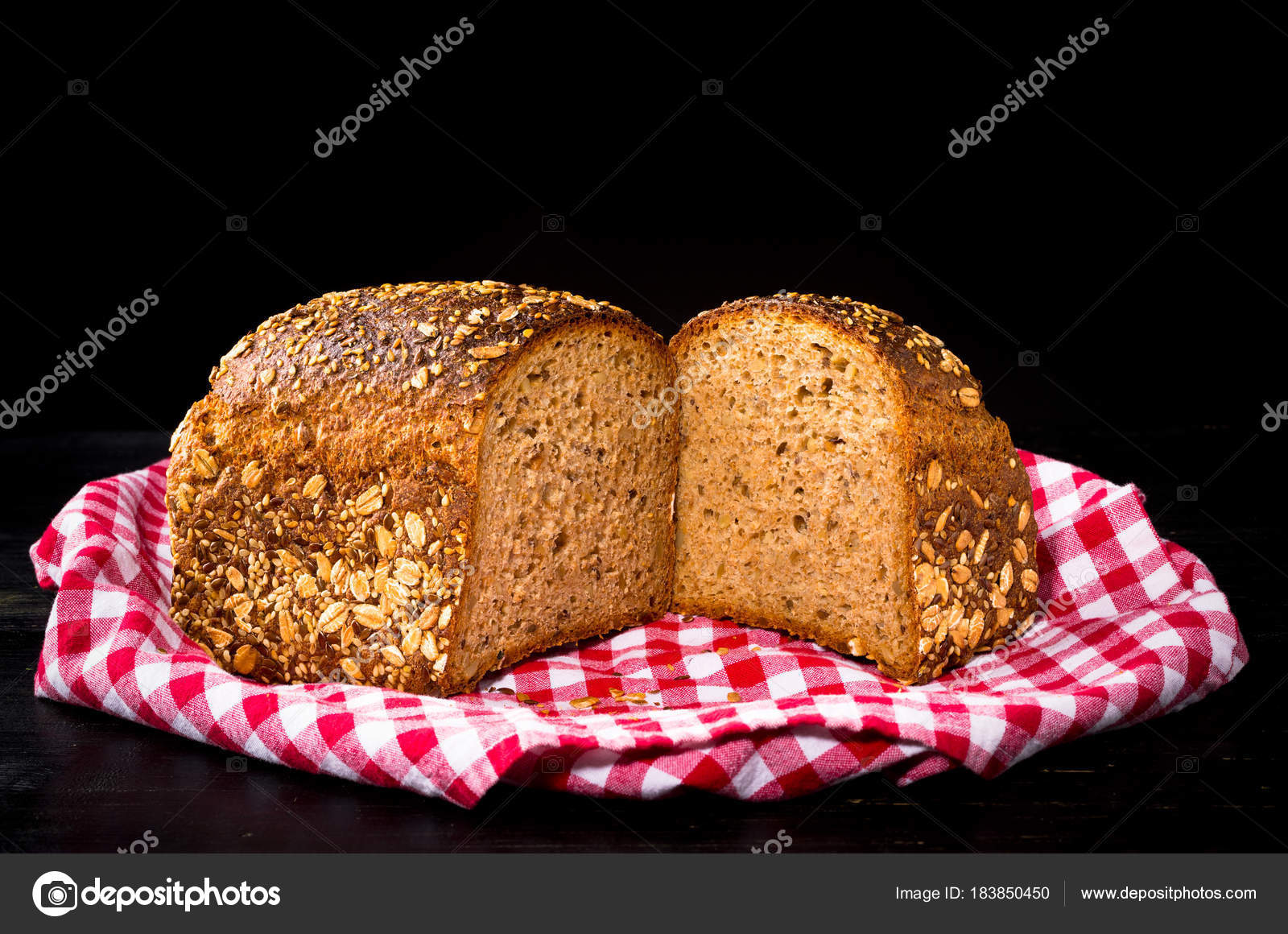 Granary Spelt Bread On Red Kitchen Towel And Black