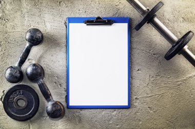 Fitness veya vücut geliştirme arka plan. Eski demir halter salonunda beton zemin üzerinde. Yukarıdan çekilmiş, en iyi görünümü fotoğraf