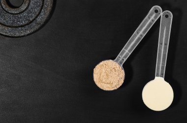 Siyah arka plan üzerine peynir altı suyu protein Kepçe. Üstten Görünüm