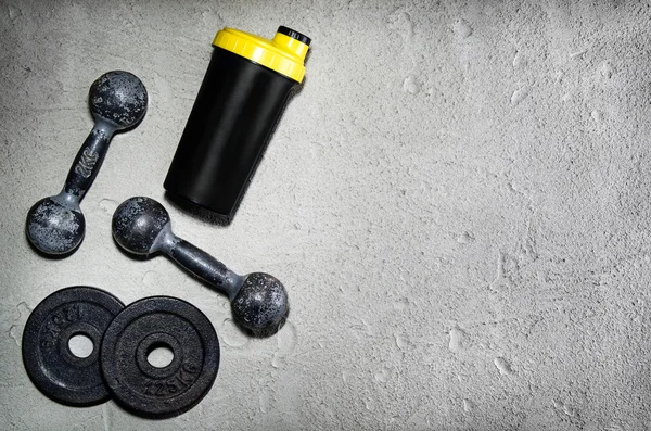 Fitness or bodybuilding background. Old iron dumbbells on conrete floor in the gym. Photograph taken from above, top view — Stock Photo, Image