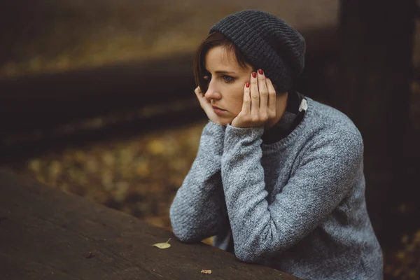 Porträt einer traurigen Frau, die allein im Wald sitzt. Einsamkeit. Millenischer Umgang mit Problemen und Emotionen. — Stockfoto