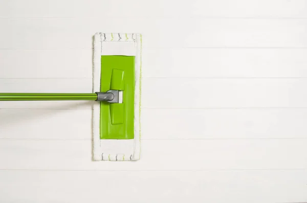 Reiniging van de vloer met bovenaanzicht van het mop op witte houten achtergrond — Stockfoto