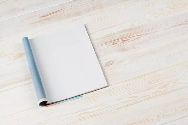 Mock-up magazines or catalog on wooden table background.