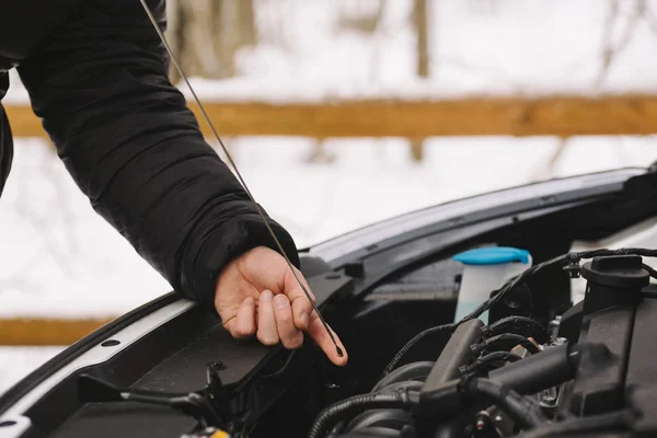 Muž kontrola hladiny oleje v autě pomocí měrky — Stock fotografie