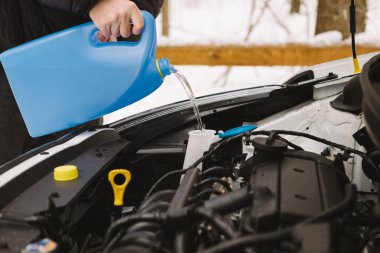 Man pouring car winter windshield washer fluid clipart