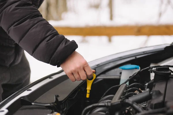 Homem verificando o nível de óleo em seu carro usando dipstick — Fotografia de Stock