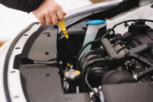 Чоловік перевіряє рівень нафти у своїй машині за допомогою дипсика — стокове фото