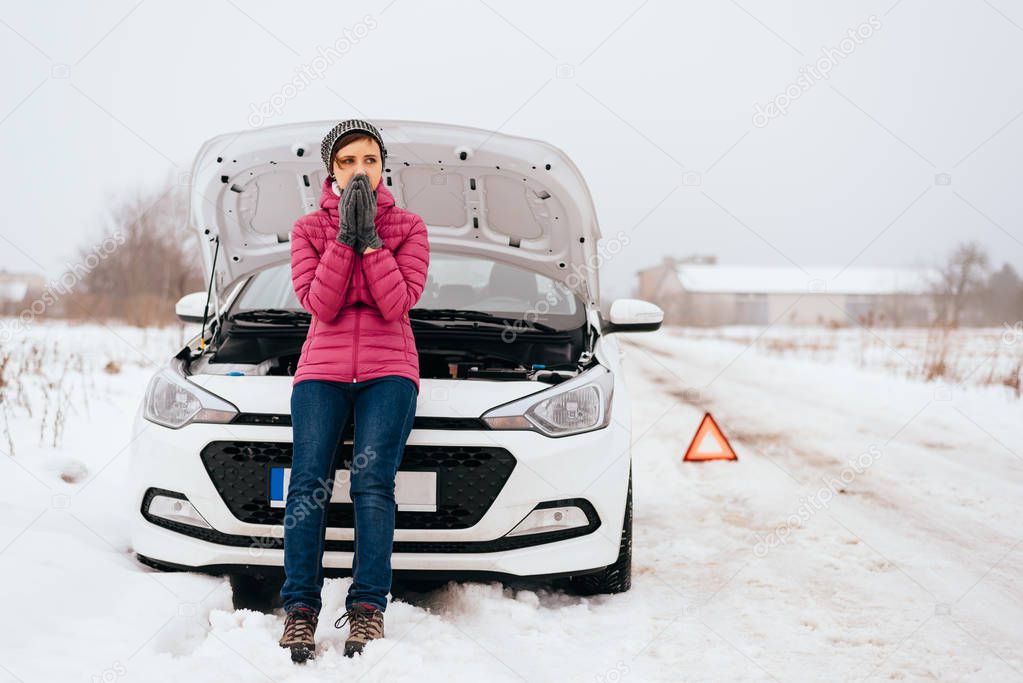 Woman waiting for help or assistance - winter car breakdown