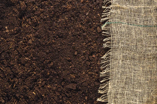 Textura fértil del suelo del jardín con vista superior de fondo de tela de yute — Foto de Stock