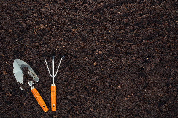 Инструменты для садоводства на текстуре садового грунта
