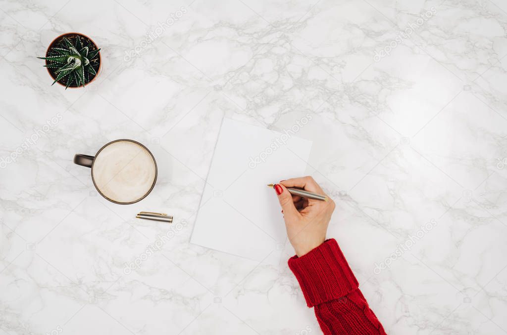 Handwriting in blank notebook on white marble table background