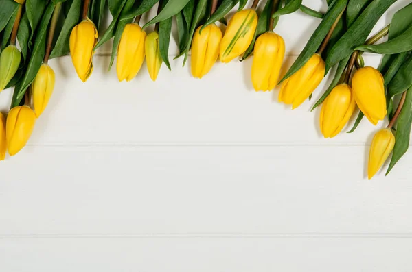 Фон рамы с желтыми тюльпанами, на белом деревянном столе — стоковое фото