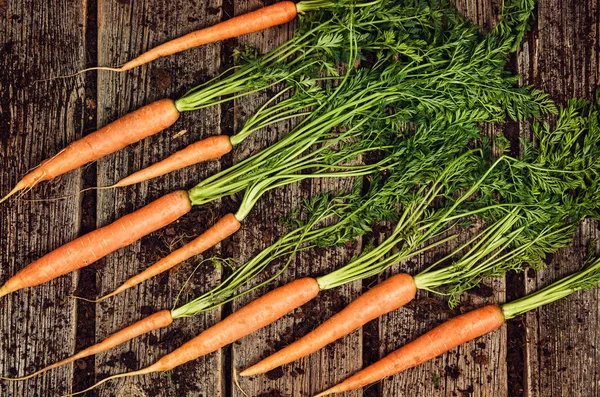 Makanan sayur mentah, wortel top view pada latar belakang kayu tua — Stok Foto