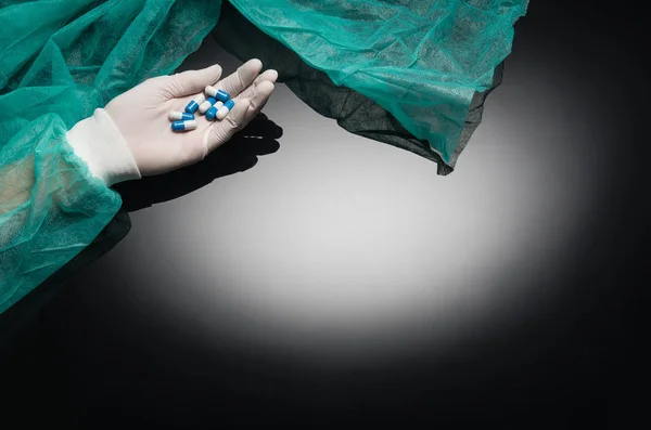 Médicos mão segurando pílulas no fundo preto com espaço de cópia — Fotografia de Stock
