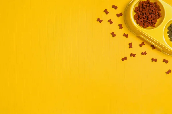 Собачья еда и аксессуары на желтом фоне вид сверху — стоковое фото