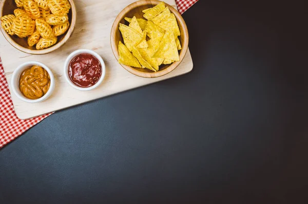 Patatas fritas y bocadillos en la mesa de pizarra negra, vista superior — Foto de Stock