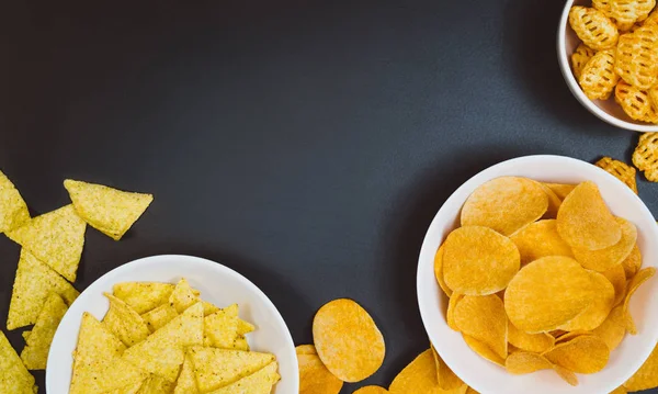 Patatas fritas y bocadillos en la mesa de pizarra negra, vista superior — Foto de Stock