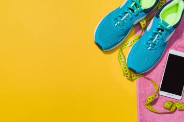 Sarı arka plan, üstten görünüm sahte Fitness aksesuarlar