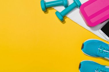 Sarı arka plan, üstten görünüm sahte Fitness aksesuarlar