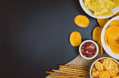 Patates cipsi ve siyah arduvaz tablo, üstten görünüm snacks
