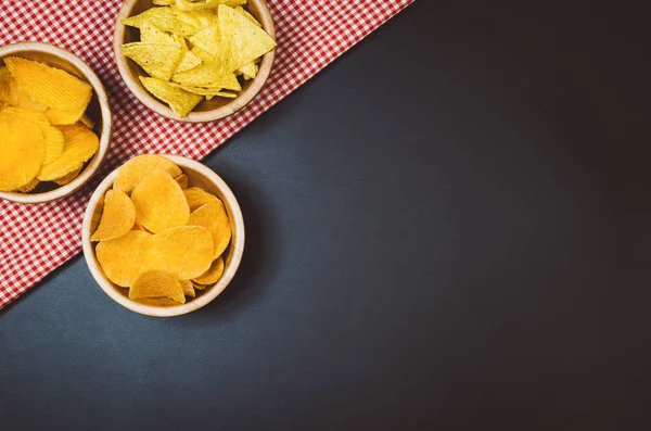 Patatas fritas y bocadillos en la mesa de pizarra negra, vista superior — Foto de Stock