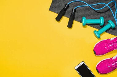 Sarı arka plan, üstten görünüm sahte Fitness aksesuarlar