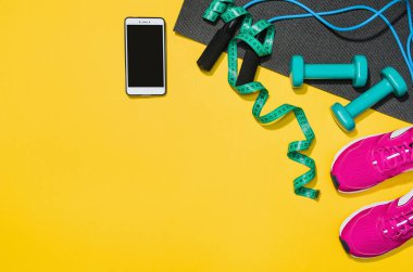Sarı arka plan, üstten görünüm sahte Fitness aksesuarlar
