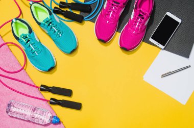 Sarı arka plan, üstten görünüm sahte Fitness aksesuarlar
