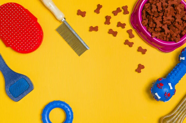 Comida para perros y accesorios sobre fondo amarillo vista superior — Foto de Stock