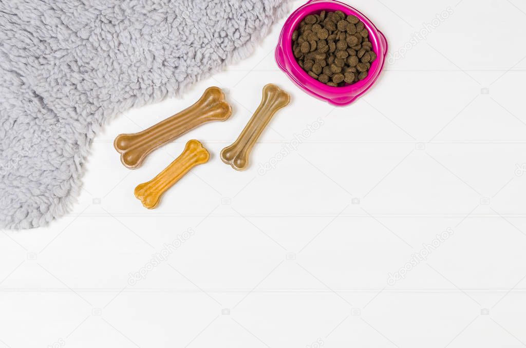 Dry dog pet food on white wooden background top view