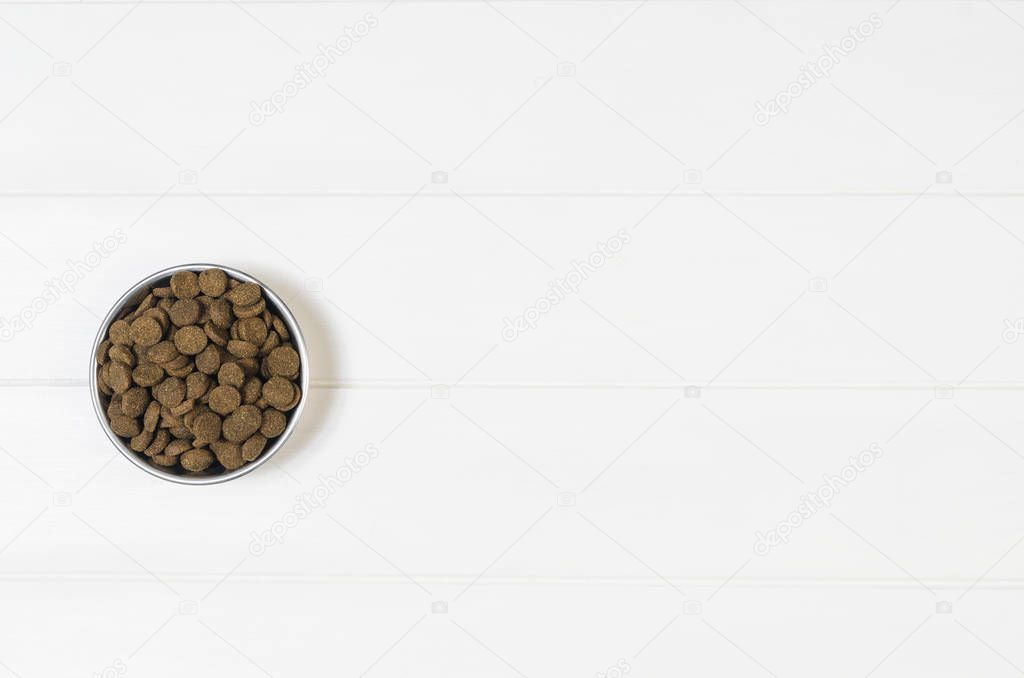 Dry dog pet food on white wooden background top view