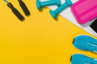 Sarı arka plan, üstten görünüm sahte Fitness aksesuarlar