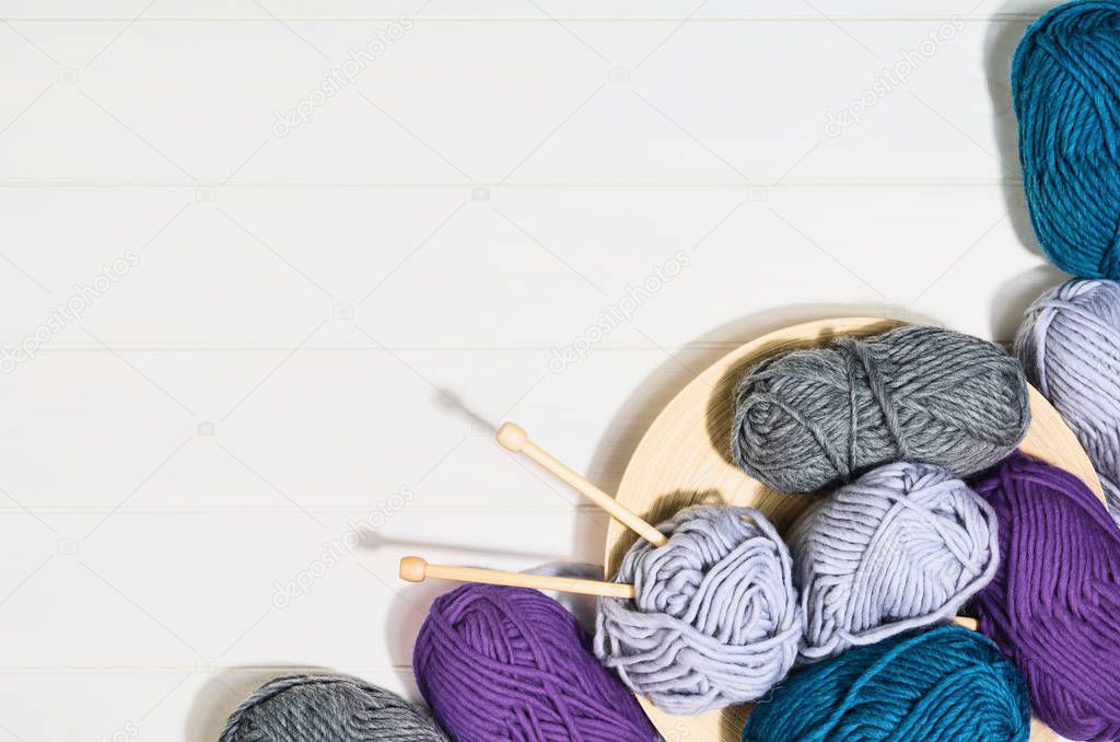 Knitting accessories top view on white wooden background