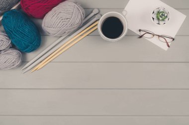 Örgü yün ve iğneler gri ahşap masa üzerinde arka plan