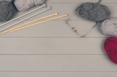 Örgü yün ve iğneler gri ahşap masa üzerinde arka plan