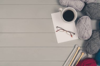 Örgü yün ve iğneler gri ahşap masa üzerinde arka plan